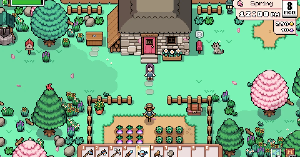Player character standing outside a stone farmhouse with a red door, a mailbox and a grey cat, above a small fenced crop plot in spring in Fields of Mistria