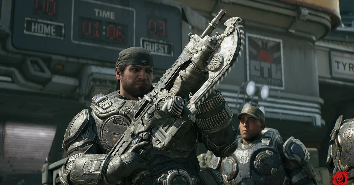 Marcus Fenix raises a Lancer in front of a stadium scoreboard as a COG soldier looks on in Gears of War E-Day