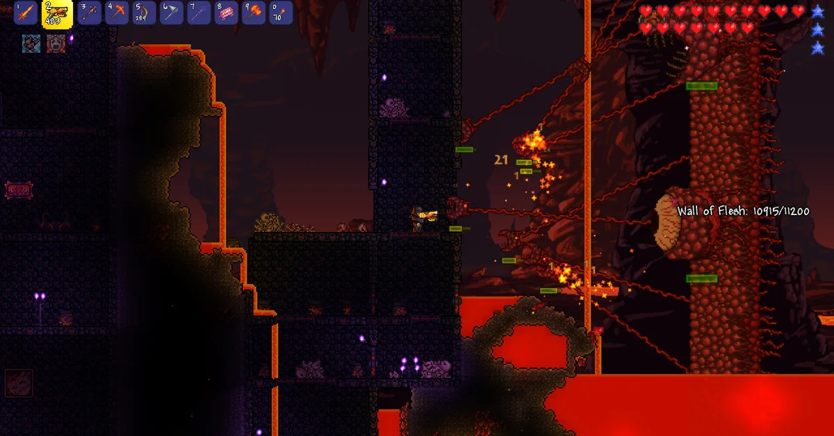 A Terraria player fighting the Wall of Flesh from a dark brick tower above pools of lava in the Underworld