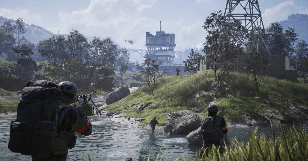 WARDOGS soldiers wade across a river toward a tall industrial tower in the distance