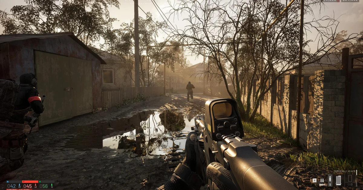 First-person view down a muddy WARDOGS village alley with a red-dot rifle raised