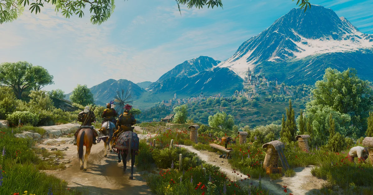 Riders on a path through a green valley below a snowy mountain in an official The Witcher 3 screenshot