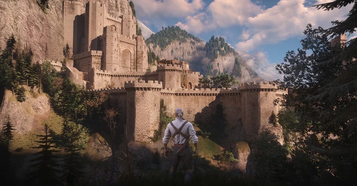 Geralt looking up at a sunlit hilltop castle in an official The Witcher 3 screenshot