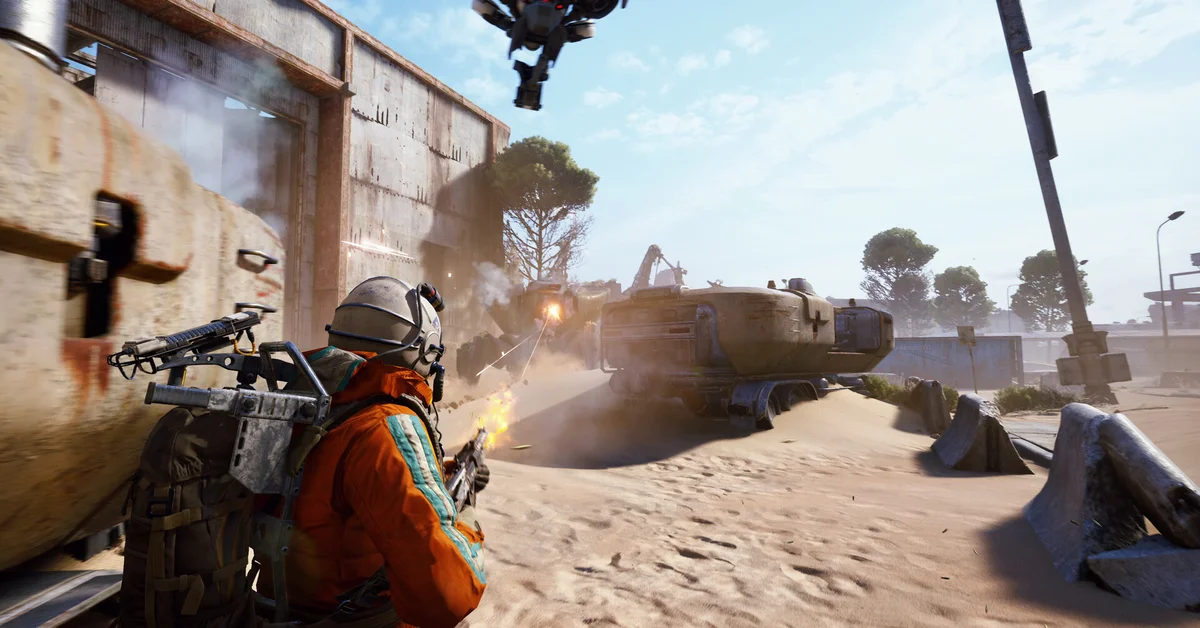 A raider in an orange suit fires from cover at an ARC drone hovering over a sandy road in ARC Raiders