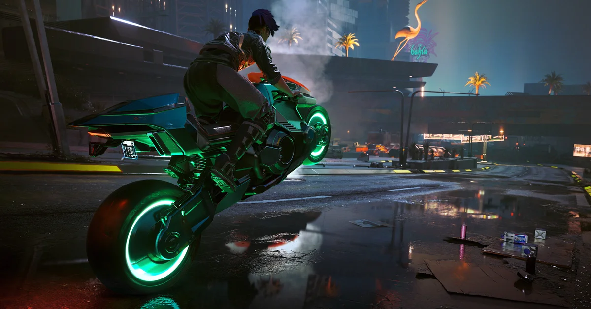 A rider pulls a wheelie on a neon green motorcycle on a rain-slicked Night City street in Cyberpunk 2077