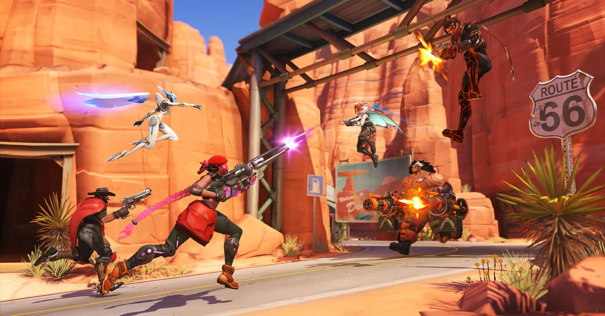 Heroes fighting in a desert town with a Route 66 sign in Overwatch