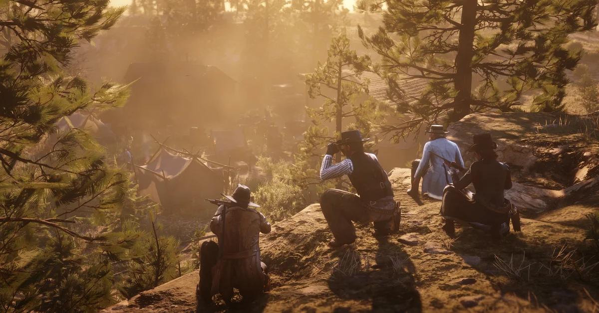 Four riders crouched on a sunlit rocky ridge above a camp of canvas tents in a pine forest in Red Dead Online